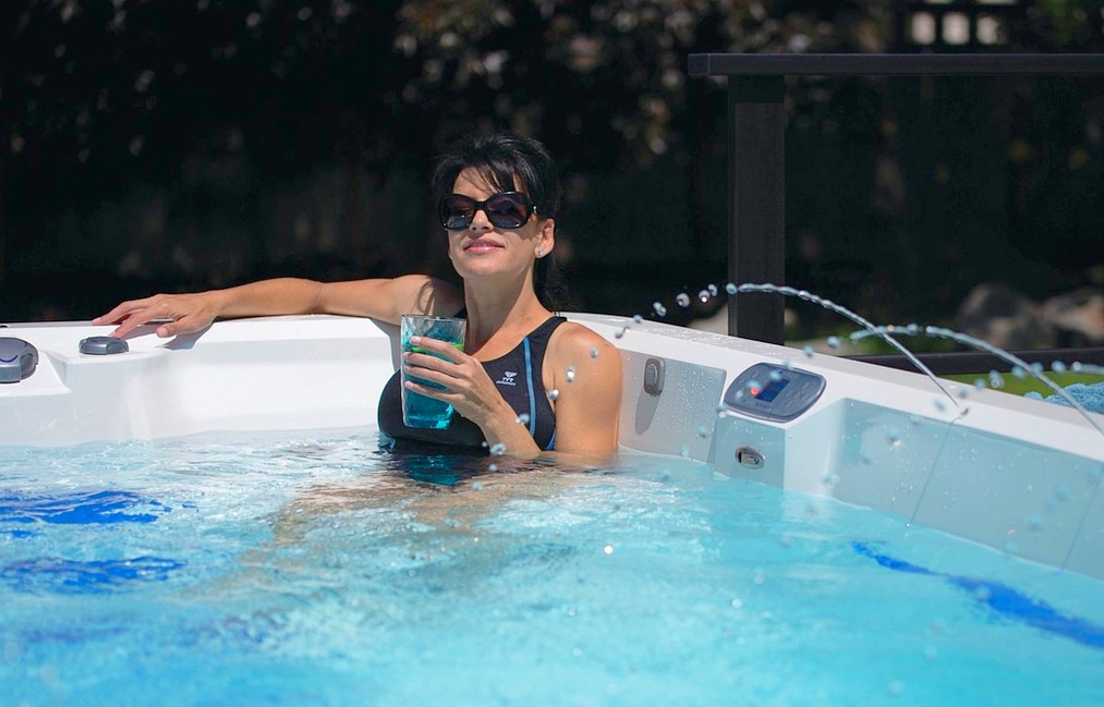 Best Time To Buy a Hot Tub - woman in black bathing suit relaxing in hot tub